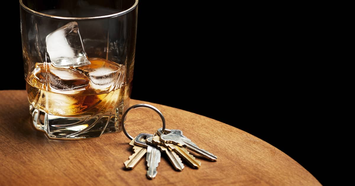 glass of booze next to a set of keys after a DUI