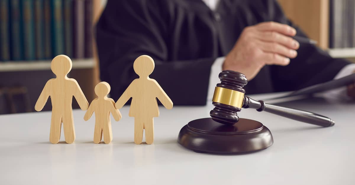 a family law lawyer helps clients at a desk | The Bishop Law Group